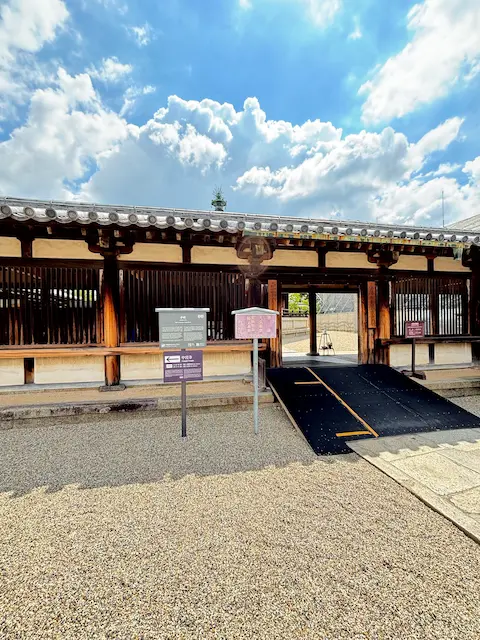 日本の伝統的な建物の入口。晴れた空と雲が見える。