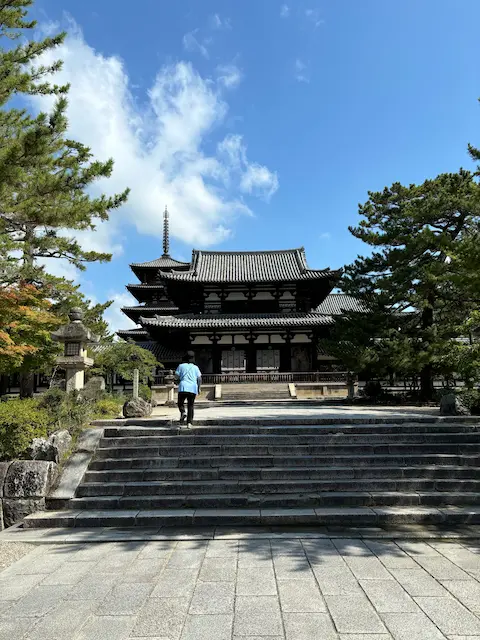階段を上がる男性と伝統的な日本の寺院の風景