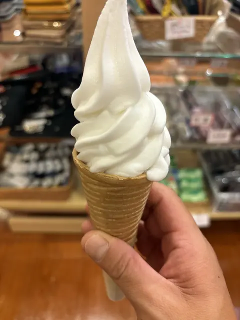 手に持たれたソフトクリームが入ったコーン