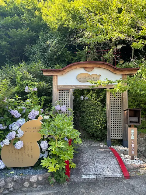 美しい花々と緑に囲まれた入口の門。