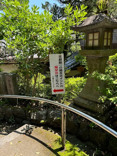 京都の展望ポイントへの案内看板と緑の植物